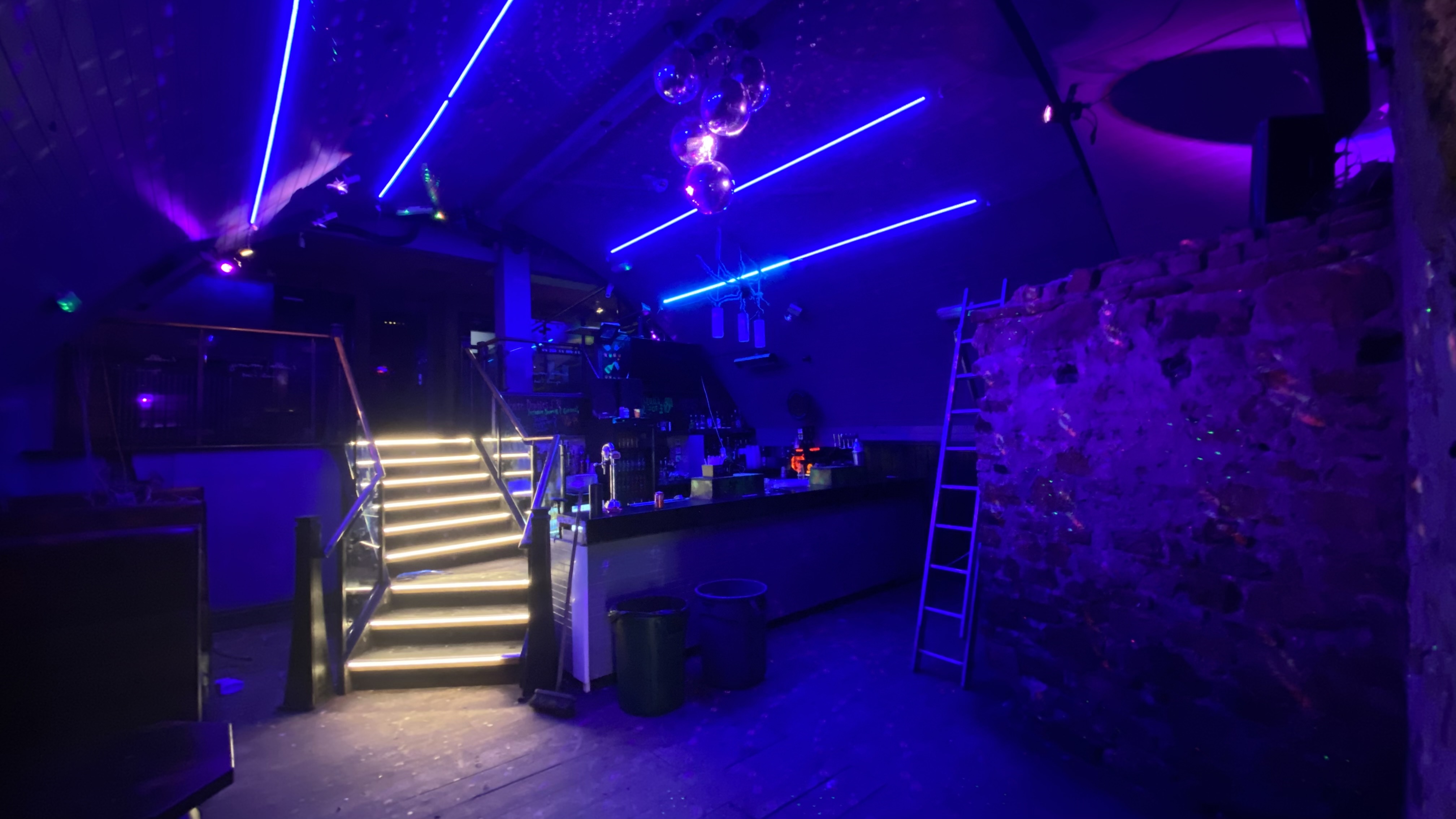 Nightclub interior with integrated blue lighting and illuminated staircase